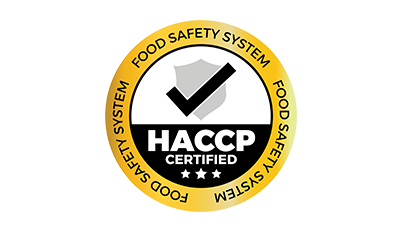 A round seal with a yellow border featuring the text "FOOD SAFETY SYSTEM" repeating around the edge. Inside, a grey shield with a black checkmark is above the words "HACCP CERTIFIED" in bold black letters. Three stars are depicted below the text.